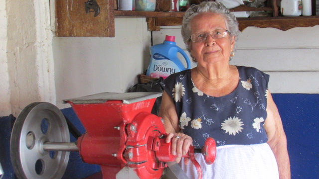 Doña Blanca Castillo junto a su moledor de maíz
